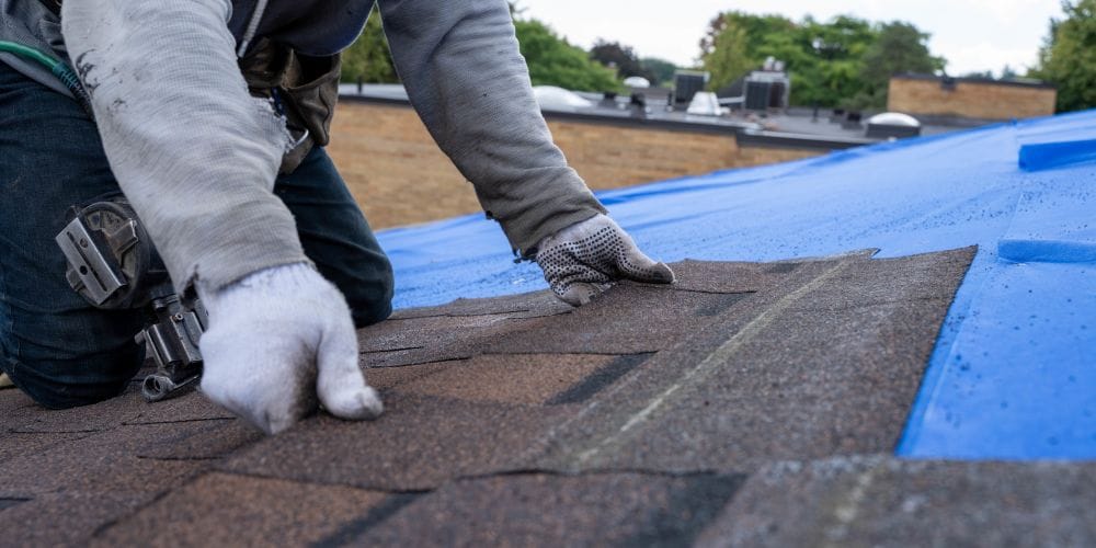 Construction worker installing a roof on a new house.