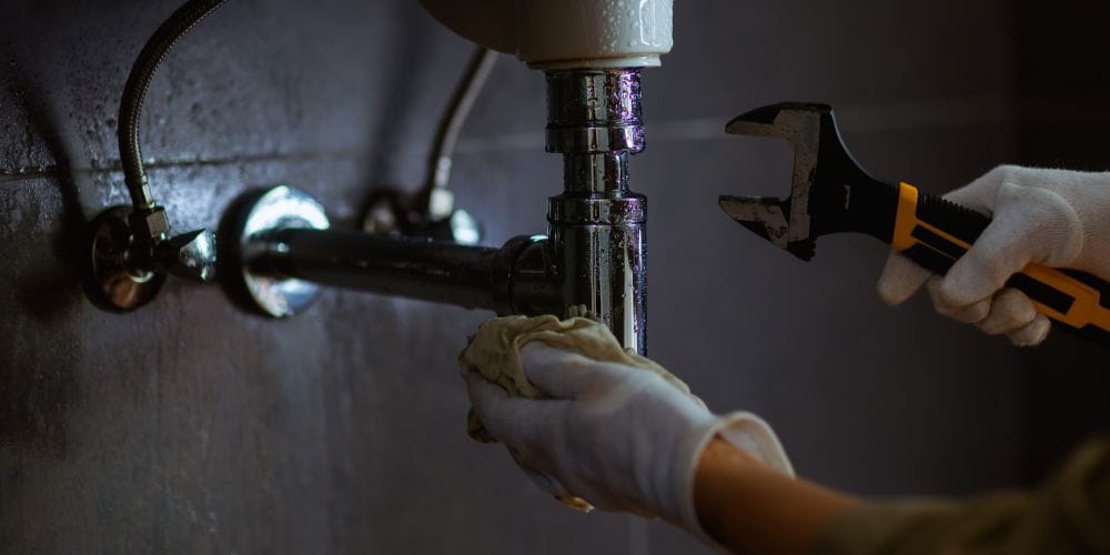 Plumber fixing leaky pipe.